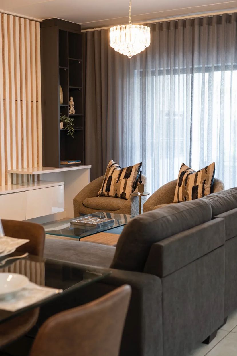 Raffinato Property Group Lounge Project - Grand open-plan living room with expansive sofa configuration, textured cushions, and custom architectural styling details.